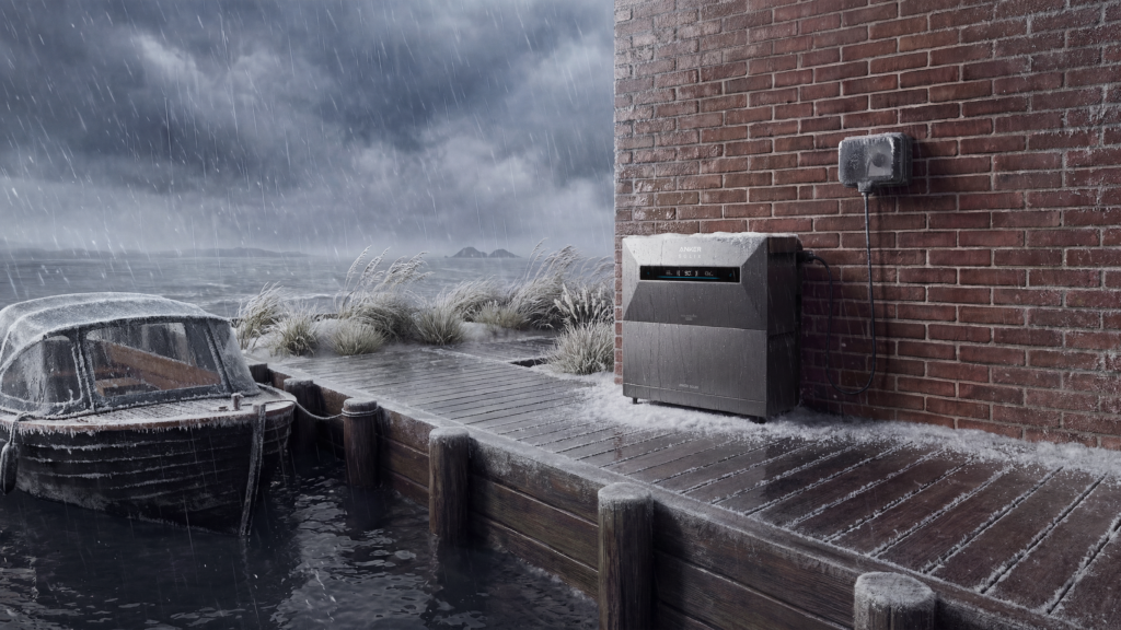 Sind Sie unsicher, ob Sie eine Heimbatterie im Freien aufstellen sollen? Tragbare Anker Solix-Stromstation in Schwarz vor einer Backsteinmauer bei stürmischem, nassem Wetter am Ufer mit einem verschneiten alten Holzboot und grau bewölktem Himmel